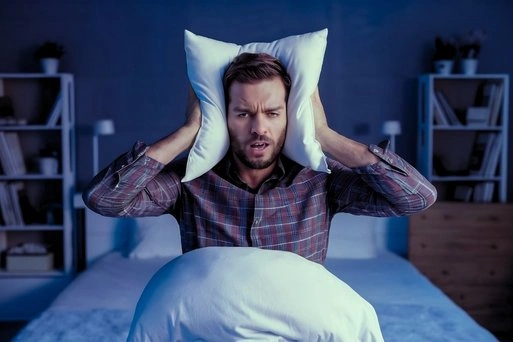 Individual experiencing disrupted sleep, a common symptom of sleep disorders such as insomnia.