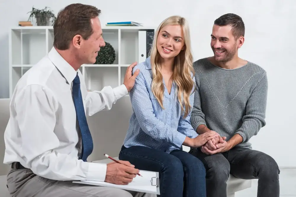 Psychiatrist speaking with a smiling couple during a mental health consultation near Detroit